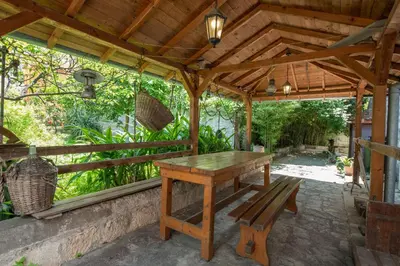 a wooden table and bench under a wooden pergola at Radimir 101 in Kotor