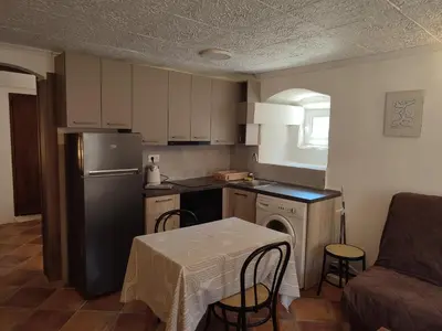 a small kitchen with a table and a refrigerator at Radimir 101 in Kotor