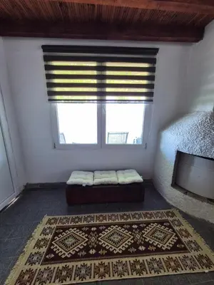 a room with a window with a bed and a rug at Old Fisherman House, Skadar lake in Rogani