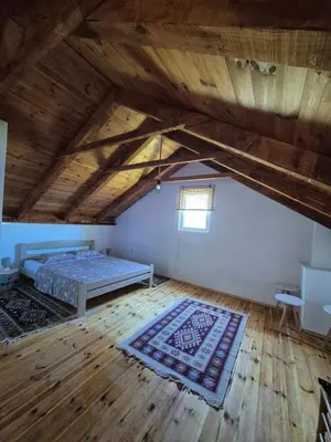 a attic room with a bed and a wooden floor at Old Fisherman House, Skadar lake in Rogani