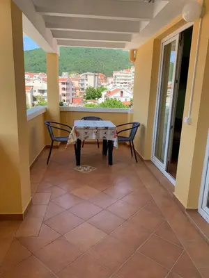 a patio with a table and chairs on a balcony at Villa Nova in Budva