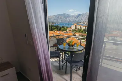 a balcony with a table and chairs and a view at Monte Bay Apartments in Kotor