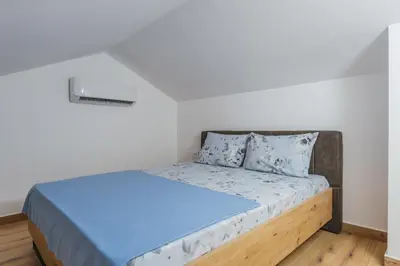 a bedroom with a bed with blue sheets and pillows at Monte Bay Apartments in Kotor