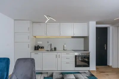 a kitchen with white cabinets and a stove top oven at Monte Bay Apartments in Kotor