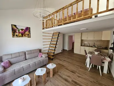 a living room with a couch and a staircase at Monte Bay Apartments in Kotor