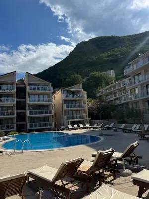 a resort with a swimming pool and chairs and buildings at Teuta Azure Apartment - Blue Horizont Complex, Sveti Stefan in Pržno