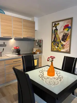 a kitchen with a table with a vase of flowers on it at Teuta Azure Apartment - Blue Horizont Complex, Sveti Stefan in Pržno