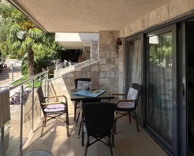a patio with a table and chairs on a balcony at Teuta Azure Apartment - Blue Horizont Complex, Sveti Stefan in Pržno