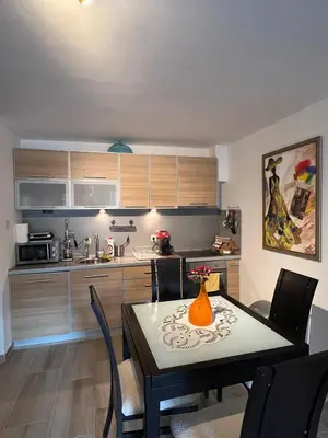 a kitchen with a dining room table with chairs and a kitchen at Teuta Azure Apartment - Blue Horizont Complex, Sveti Stefan in Pržno