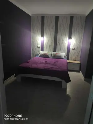 a bedroom with a purple bed with two lights on it at Apart 102 in Kućišta