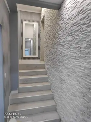 a stairway leading to a hallway with a stone wall at Apart 102 in Kućišta