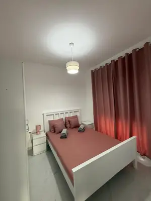 a bedroom with a large bed with red curtains at FB Apartments in Ulcinj
