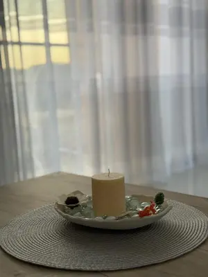 a candle on a plate on a table at FB Apartments in Ulcinj