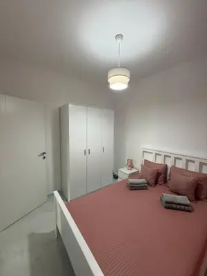 a bedroom with a large bed with red sheets at FB Apartments in Ulcinj
