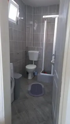 a small bathroom with a toilet and a shower at Mila apartman in Budva