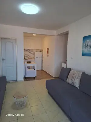 a living room with a couch and a kitchen at Mila apartman in Budva