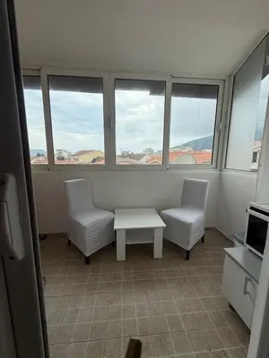 a room with two chairs and a table and windows at Mila apartman in Budva