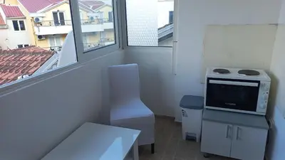 a room with a kitchen with a stove and a window at Mila apartman in Budva
