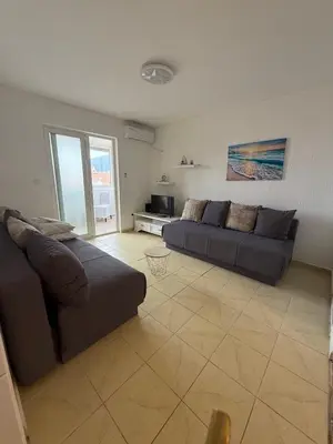 a living room with two couches in a room with at Mila apartman in Budva