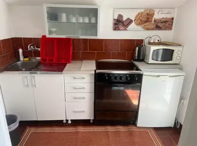 a small kitchen with a sink and a microwave at Apartmani Amira Sutomore in Sutomore