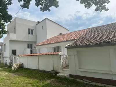 a white fence in front of a white house at Apartmani Amira Sutomore in Sutomore