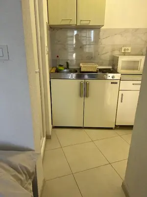 a small kitchen with a sink and a stove at Apartmani Amira Sutomore in Sutomore