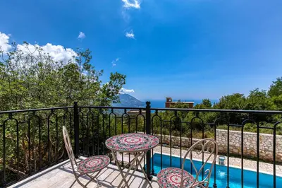 a patio with a table and chairs and a pool at Villa 53 in Lapčići