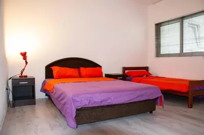 a bedroom with two beds with orange and purple sheets at Old Olive Tree Apartment in Bar