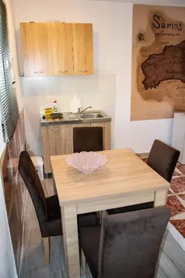 a small kitchen with a wooden table and chairs at Old Olive Tree Apartment in Bar
