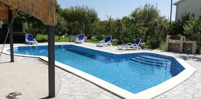 a swimming pool with lounge chairs and a swimming pool at Old Olive Tree Apartment in Bar