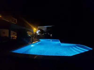 a swimming pool in the dark at night at Old Olive Tree Apartment in Bar