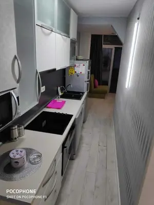 a kitchen with white cabinets and a stove top oven at Apart102 in Budva