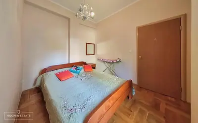 a bedroom with a bed with a blue comforter at Квартира - Солнце in Budva