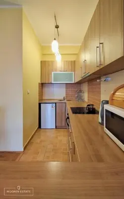 a kitchen with wooden cabinets and a white refrigerator at Квартира - Солнце in Budva