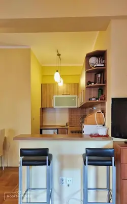 a kitchen with a counter and two bar stools at Квартира - Солнце in Budva