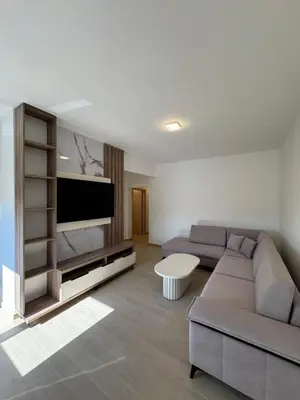 a living room with a couch and a flat screen tv at Aron Apartment in Tuzi