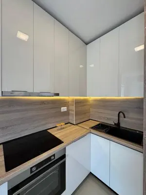 a kitchen with white cabinets and a sink at Aron Apartment in Tuzi