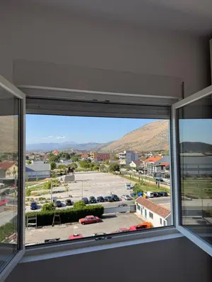 a window with a view of a parking lot at Aron Apartment in Tuzi