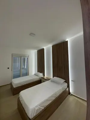 a bedroom with two beds and a window at Aron Apartment in Tuzi