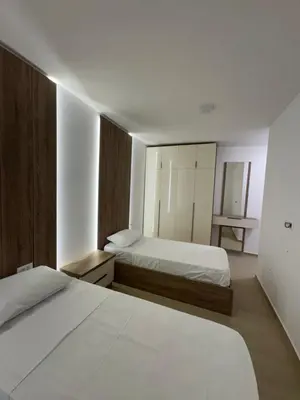 a bedroom with two beds and a mirror at Aron Apartment in Tuzi