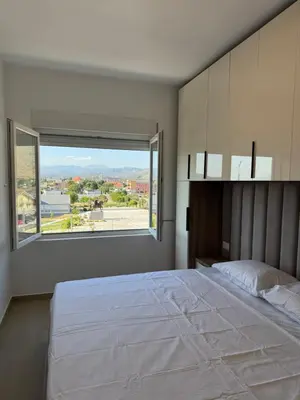 a bedroom with a large bed with a large window at Aron Apartment in Tuzi