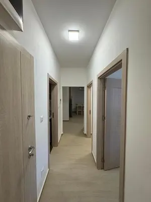 a hallway with white walls and a hallway with doors at Aron Apartment in Tuzi