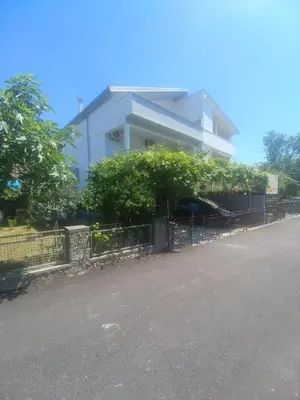 a white building with a fence in front of it at Una in Bregvija
