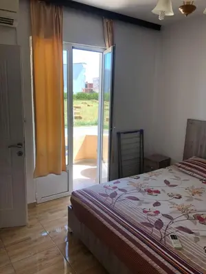 a bedroom with a bed and a sliding glass door at Apartments Yrhan in Ulcinj