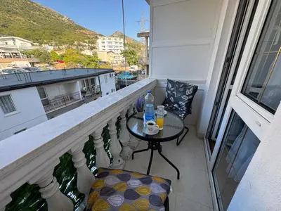 a balcony with a table and a chair on a balcony at Apartman Lord in Sutomore
