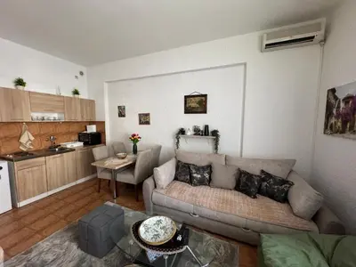 a living room with a couch and a kitchen at Apartman Lord in Sutomore