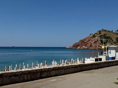 a beach with a bunch of umbrellas and the water at Apartman Lord in Sutomore