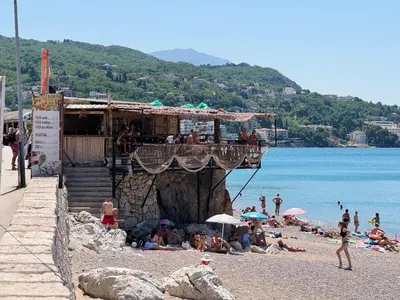 a group of people on a beach with a bar at Apartman Lord in Sutomore
