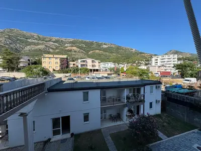 a view of a building with mountains in the background at Apartman Lord in Sutomore