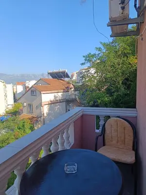 a table and a chair sitting on a balcony at Una Apartments in Budva